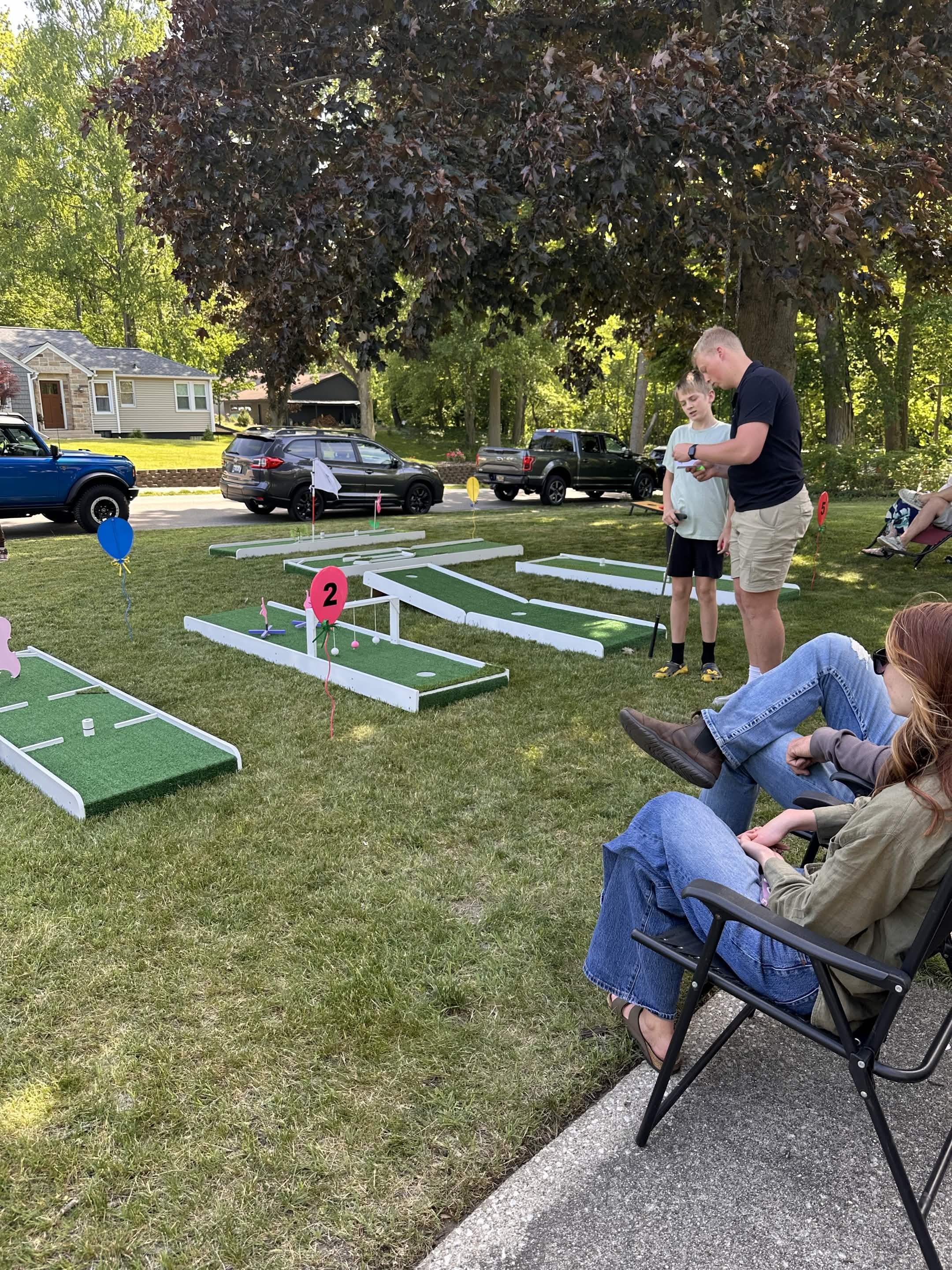 Family playing mini golf at a Puttin Party event